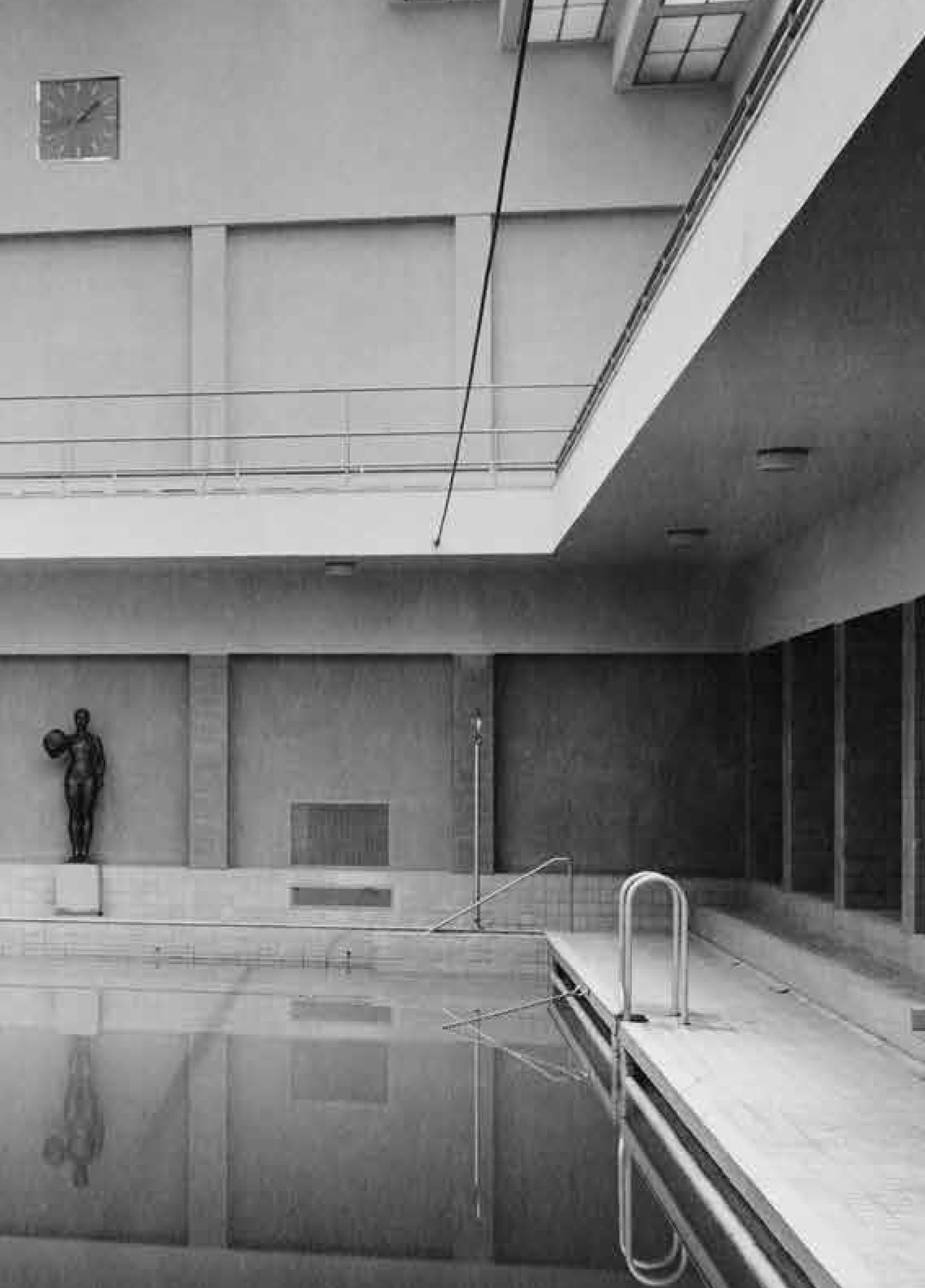 KI generiert: Das Bild zeigt ein Hallenbad im Bauhausstil mit einem großen Schwimmbecken, umgeben von schlichten, geometrischen Formen und Fenstern, die viel Licht einlassen. An der Wand steht eine Skulptur, und rechts im Bild befindet sich die Aufschrift "Dresdner Moderne 1919-1933".