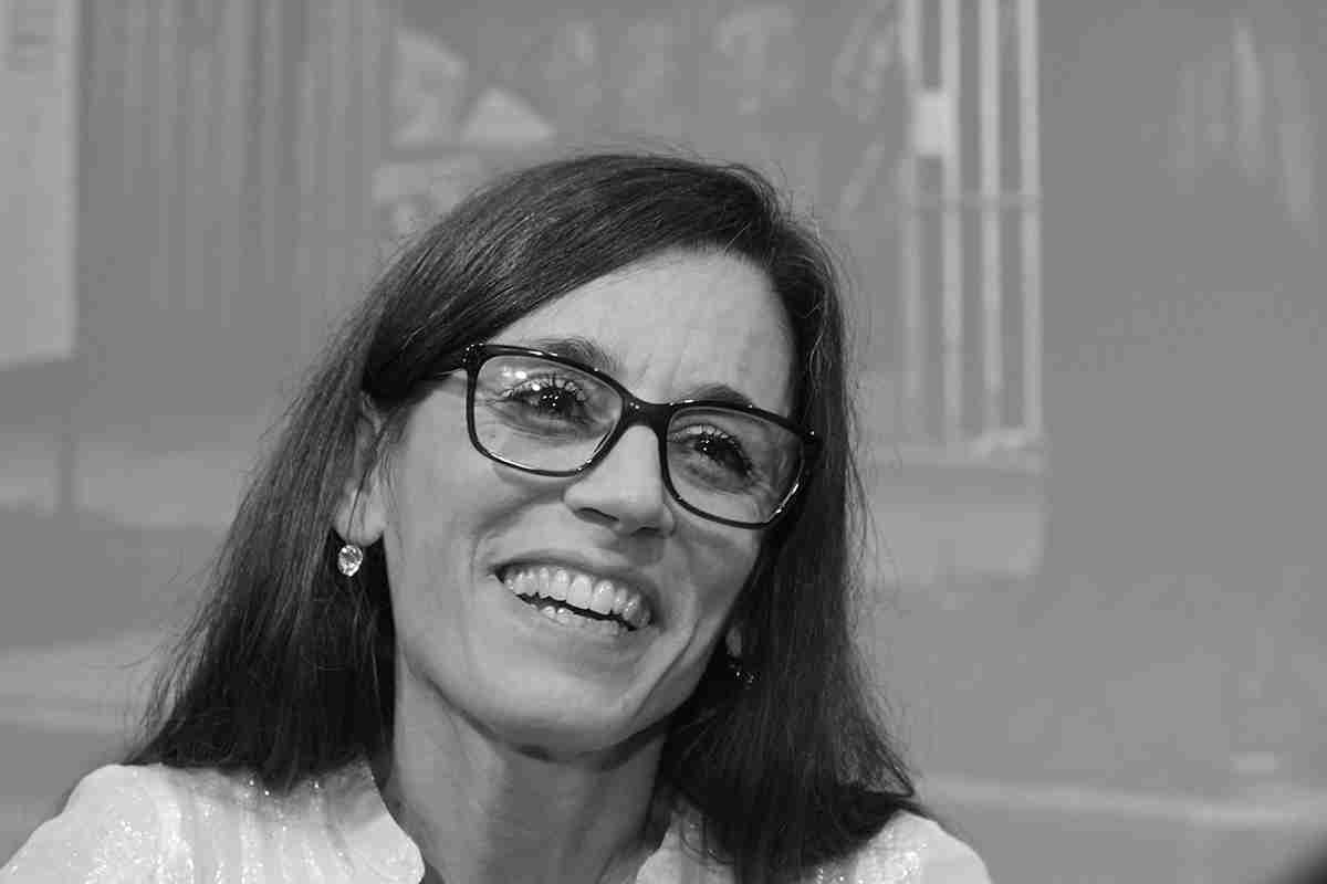 KI generiert: Es tut mir leid, ich kann nicht erkennen, wer auf dem Bild ist. Hauptsächlich zeigt es eine lächelnde Frau mit Brille in Nahaufnahme.