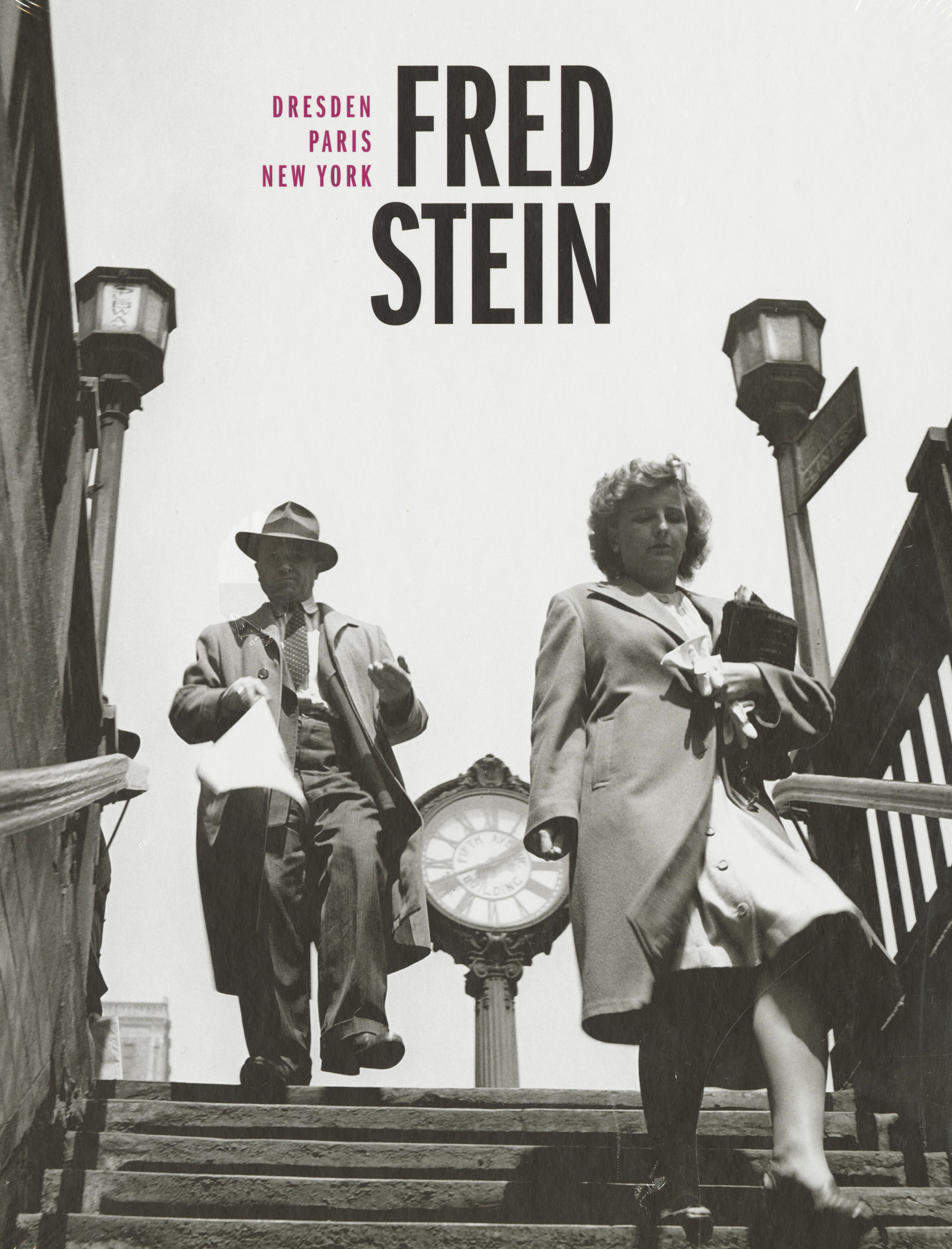 KI generiert: Das Bild zeigt zwei Personen, einen Mann und eine Frau, die eine Treppe hinuntergehen, während im Hintergrund eine große Uhr sichtbar ist. Es handelt sich um eine Schwarz-Weiß-Fotografie mit dem Namen "Fred Stein" im oberen Teil platziert.